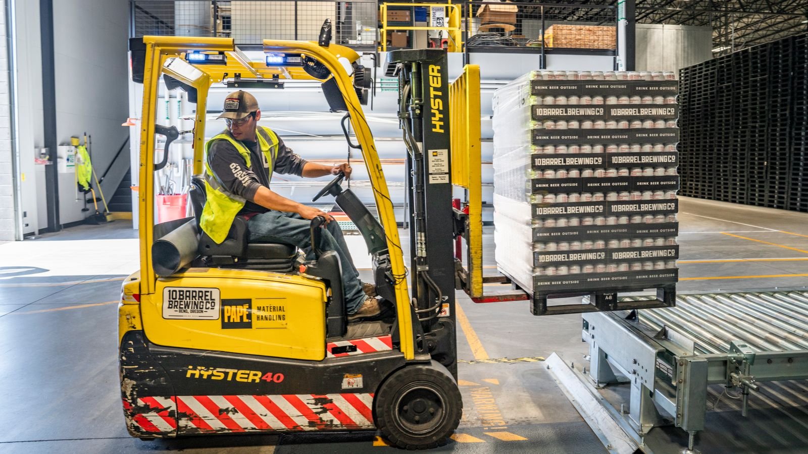 Forklift operator moving boxes inside a distribution warehouse