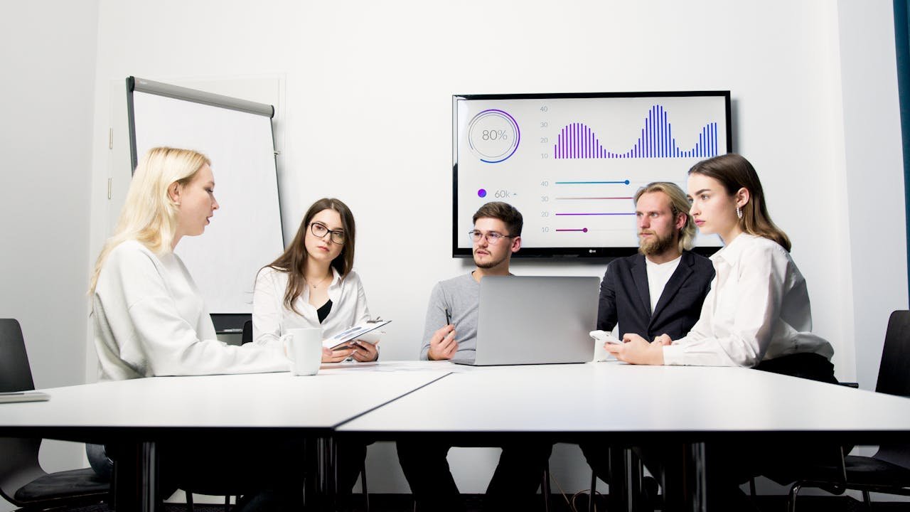 Sales team meeting reviewing cold email campaign performance and metrics