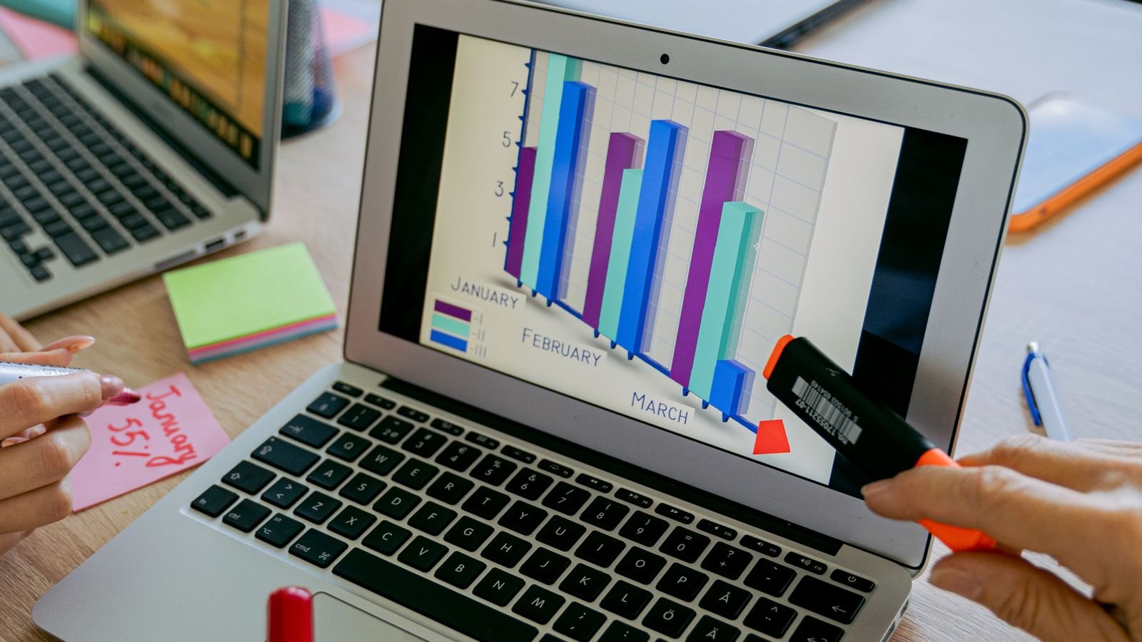 Team reviewing a business performance graph on a laptop screen